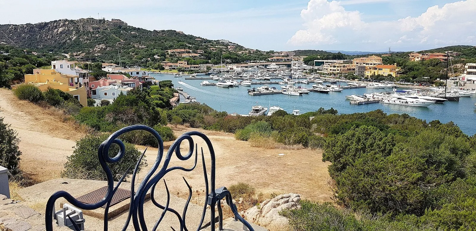 Una baia della Costa Smeralda con le barche ormeggiate e la macchia mediterranea